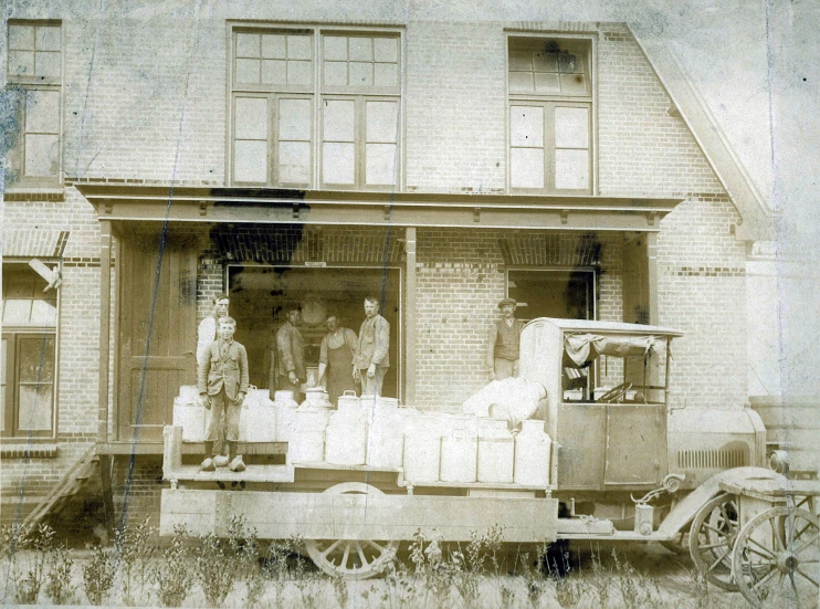 people standing outside of a car filled with milk