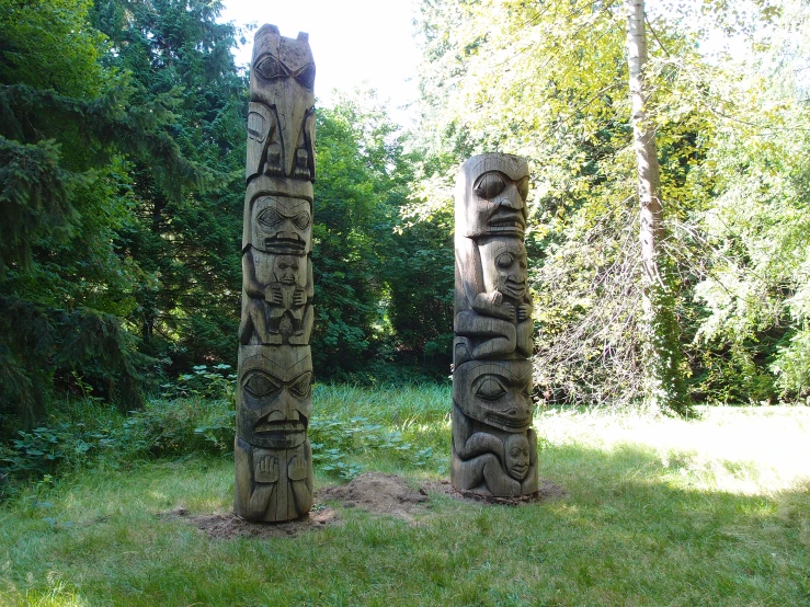the four carved totems are placed on the grass