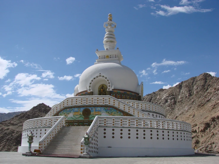 the beautifully designed building with large pillars is situated on the top of some rocks