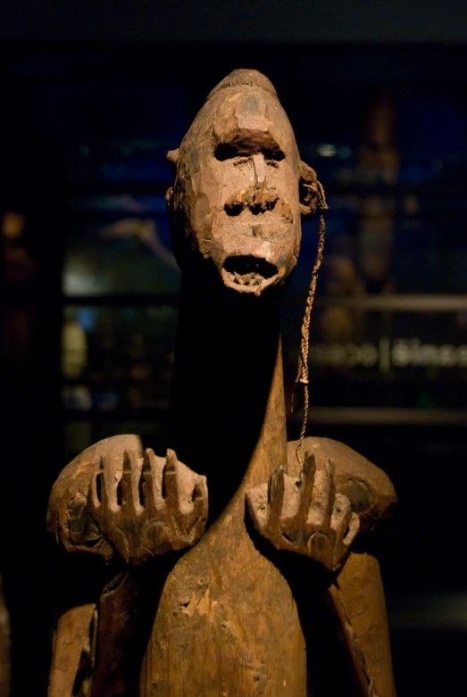 a sculpture of an alien wearing chains in a museum