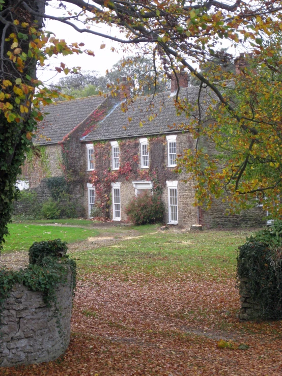 an old house in the autumn with trees around it