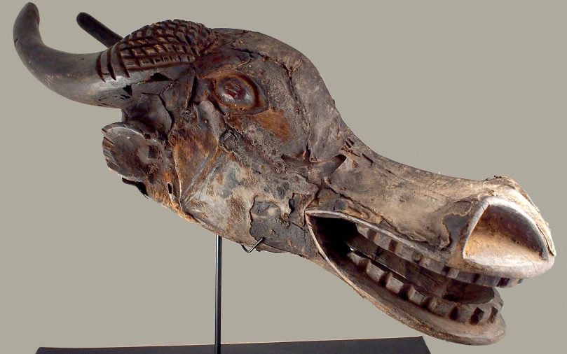 a horned bull's head on top of a wooden stand