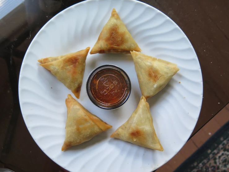 a plate topped with triangles next to a cup