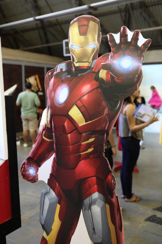 a display of an iron man costume and people standing around