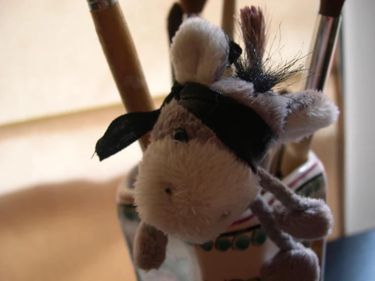 a stuffed cow sits next to the pencils