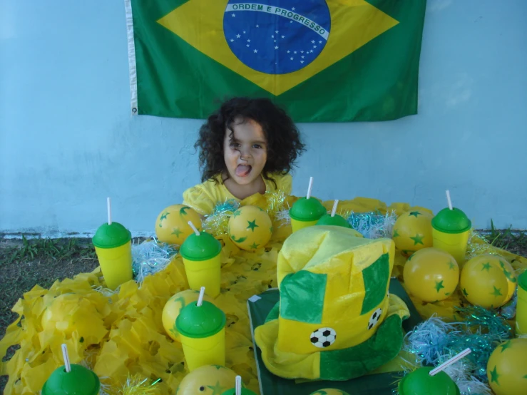 a little girl sitting in front of many decorated cupcakes