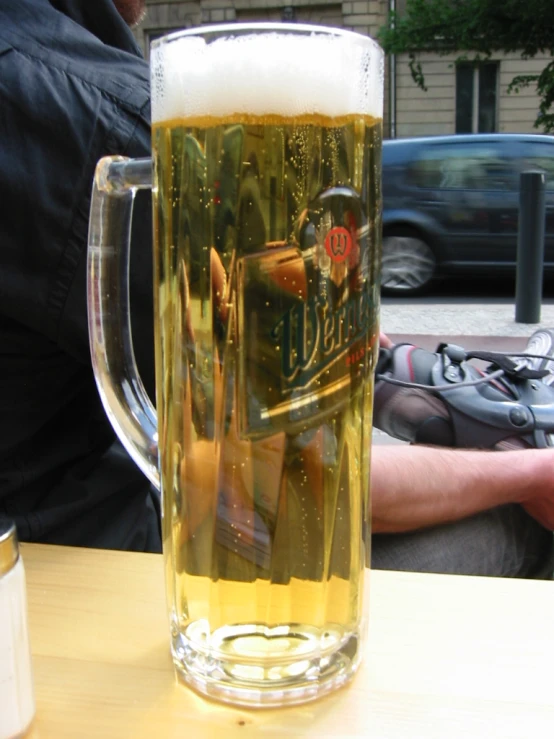 the pitcher of beer is next to a man in the background