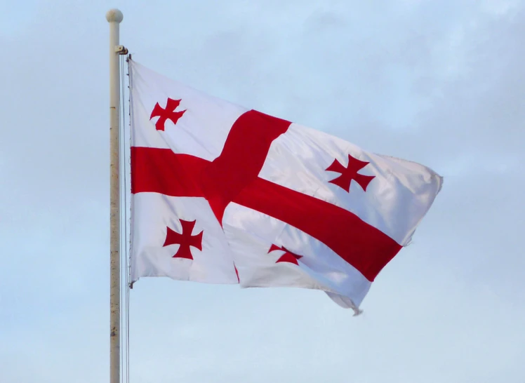 a flag is flying in the sky with clouds