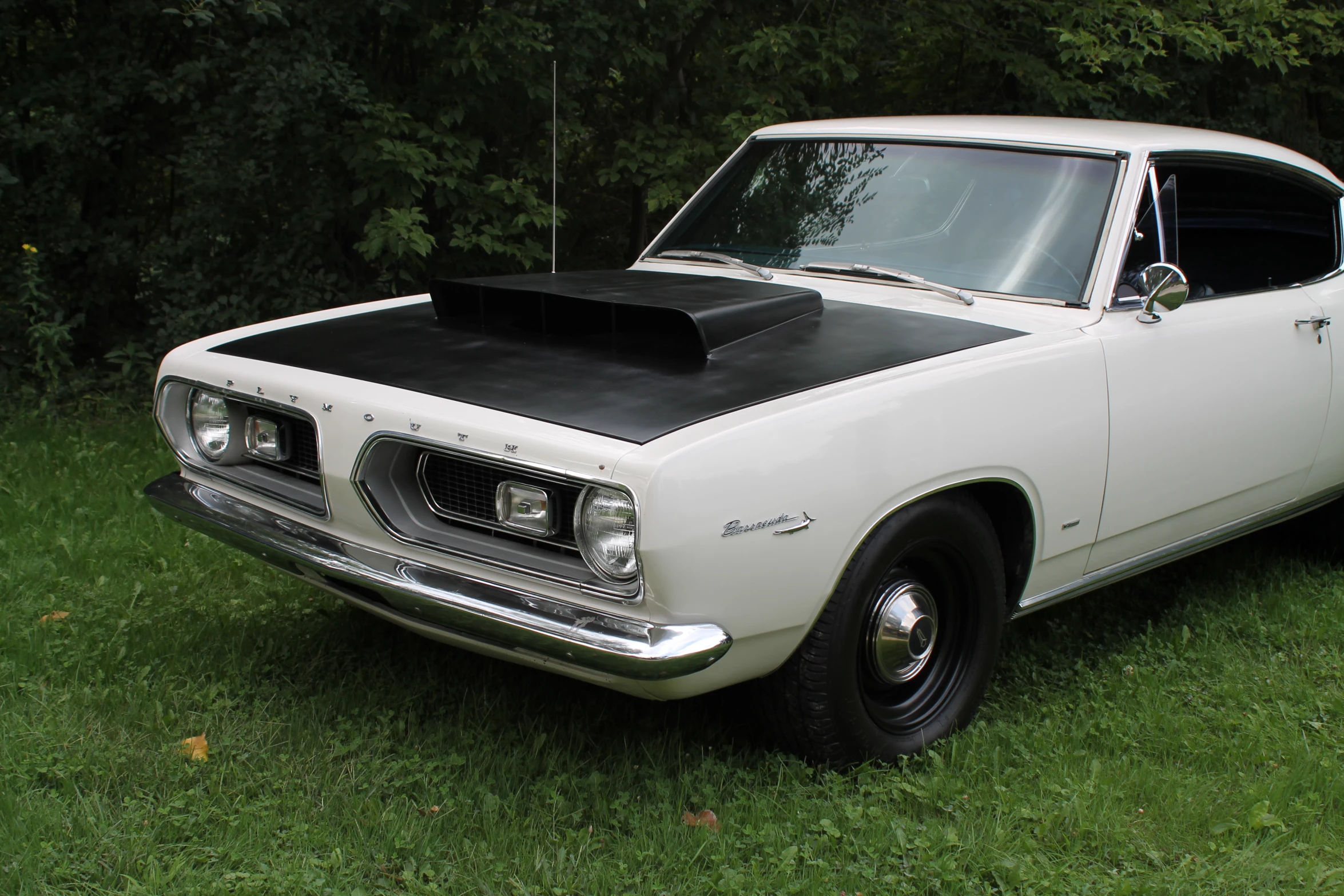 an old white car in a grassy area