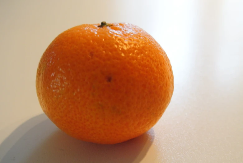 an orange sitting on a table with its top off