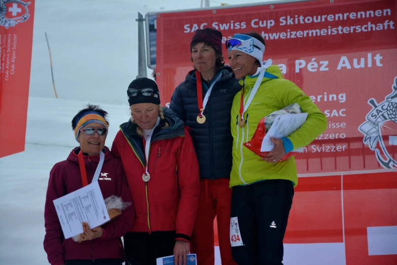 four people posing for a po while on skis