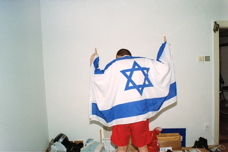 a man in shorts is wrapped up in a star of david blanket