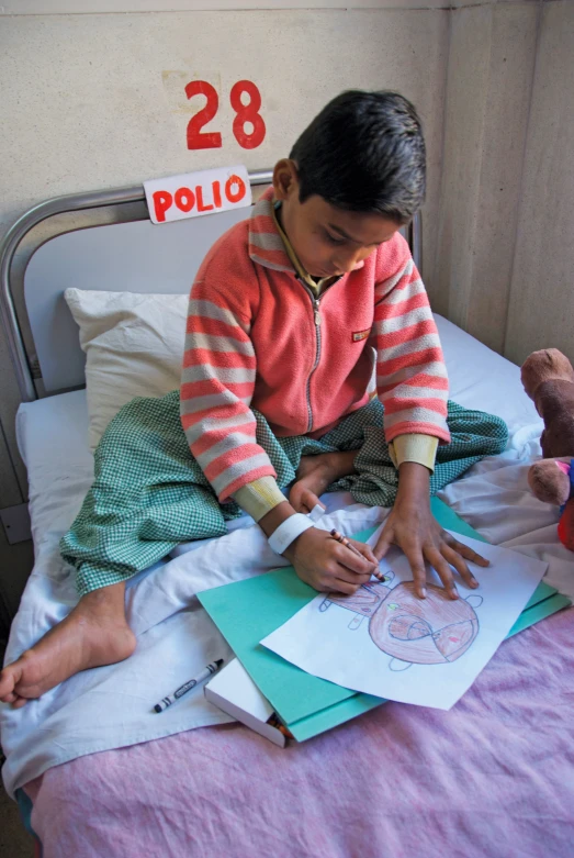 a young child is sitting on his bed looking at a picture