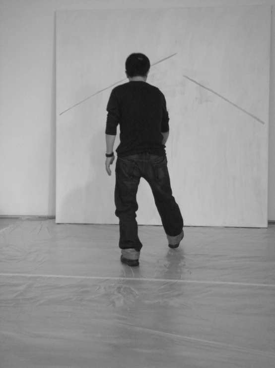 the back view of a man walking in an art gallery