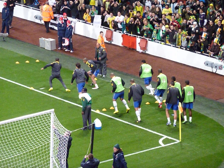 a group of men play soccer on the grass