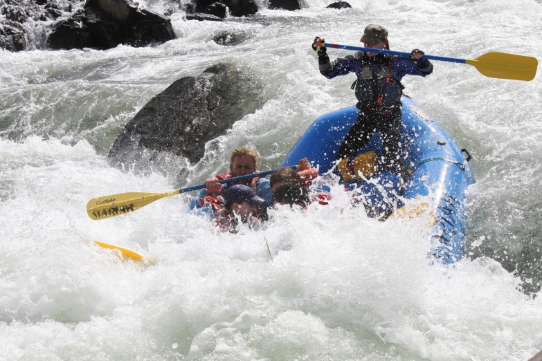 two people in a raft paddling through the white water