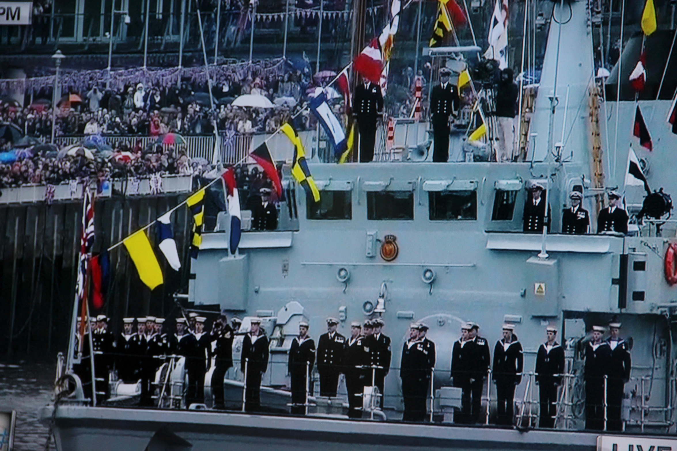 the crew of a battleship is posing with flags