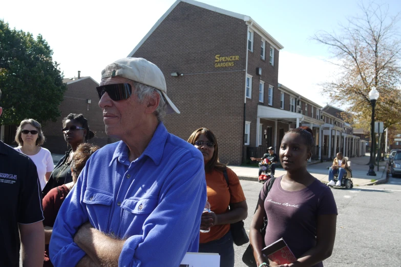 a man walking across a street with a crowd behind him