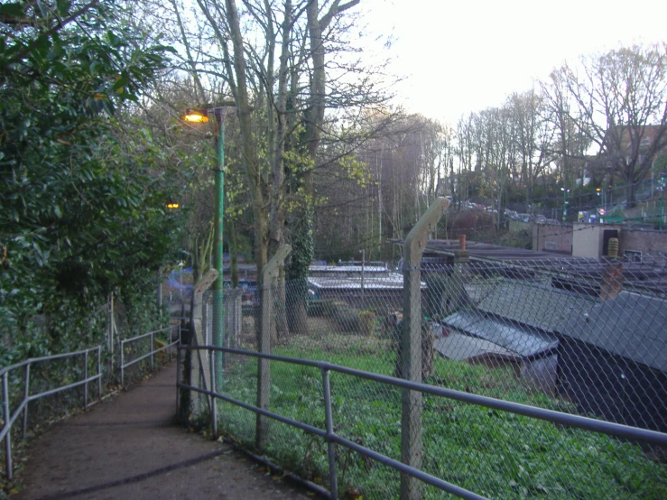 a fenced path is next to an old park area