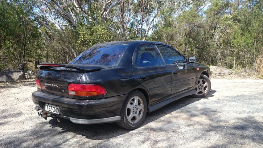 a small black car parked in the street