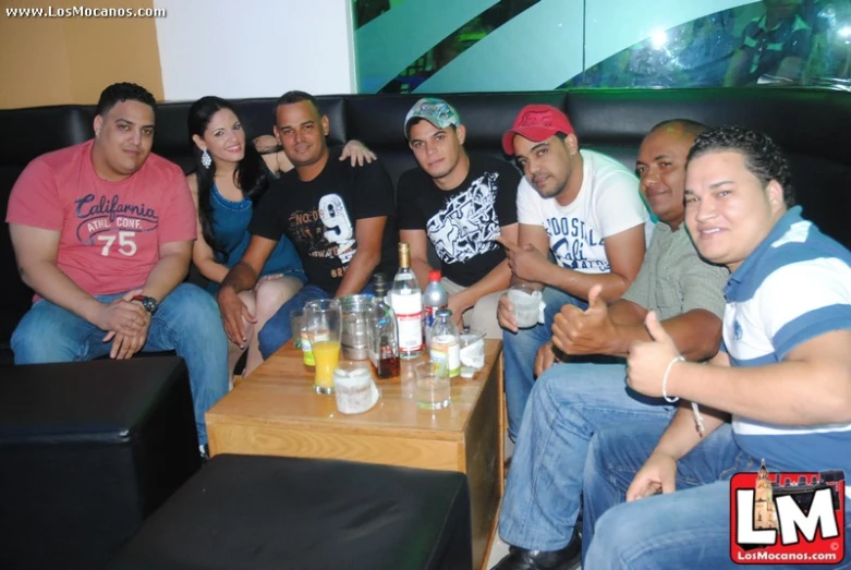 group of people with drinks sitting on top of a couch