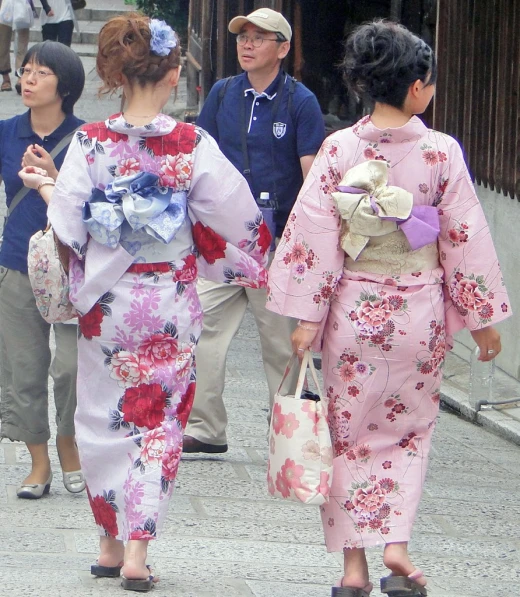 women in costumes walking down a stone path