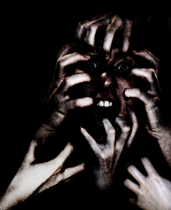 a woman's face covered in hands with eyes
