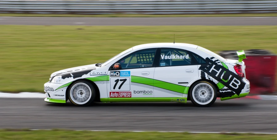 a car driving on a track near grass