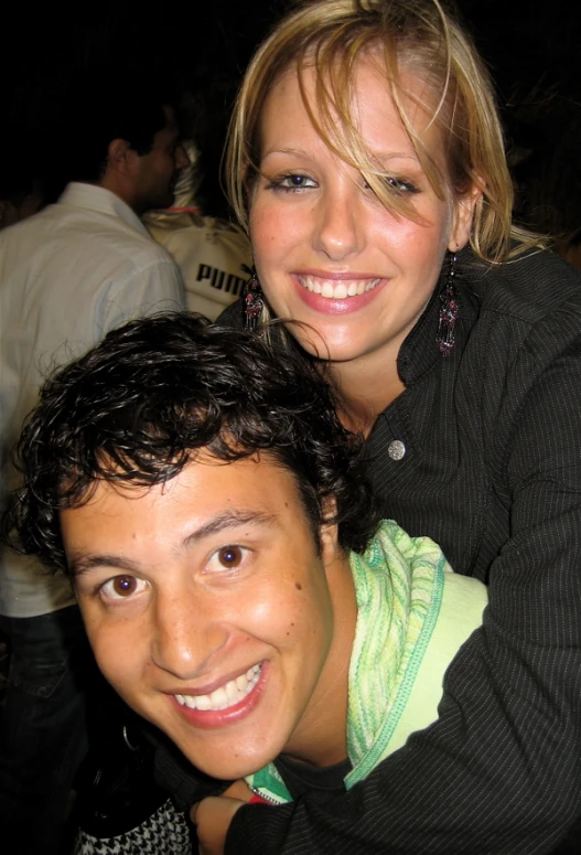 two people posing for the camera with one woman smiling