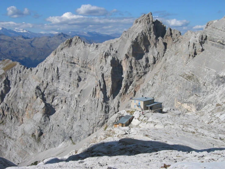 a man climbing a mountain with two mountains in the background