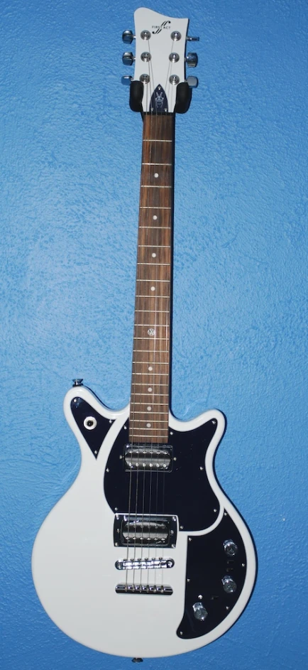 a white guitar sitting on top of a blue surface