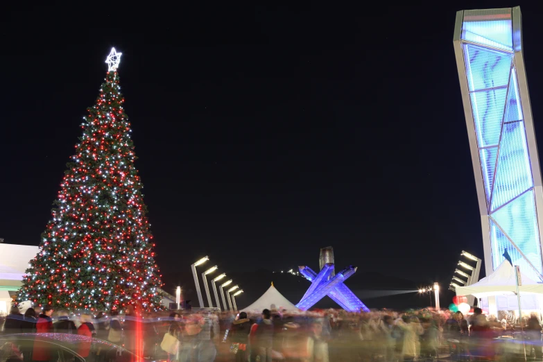 large illuminated christmas tree in front of a building