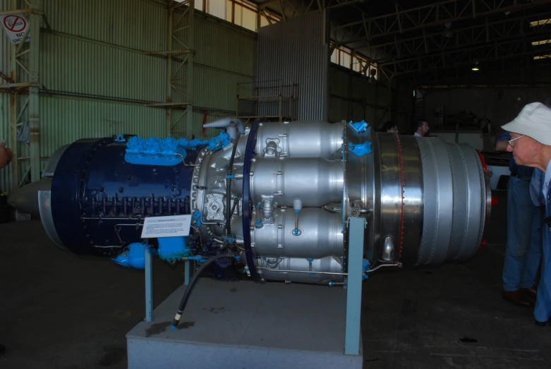 a man standing next to a large airplane engine