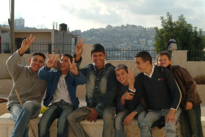 a group of men sit together and wave