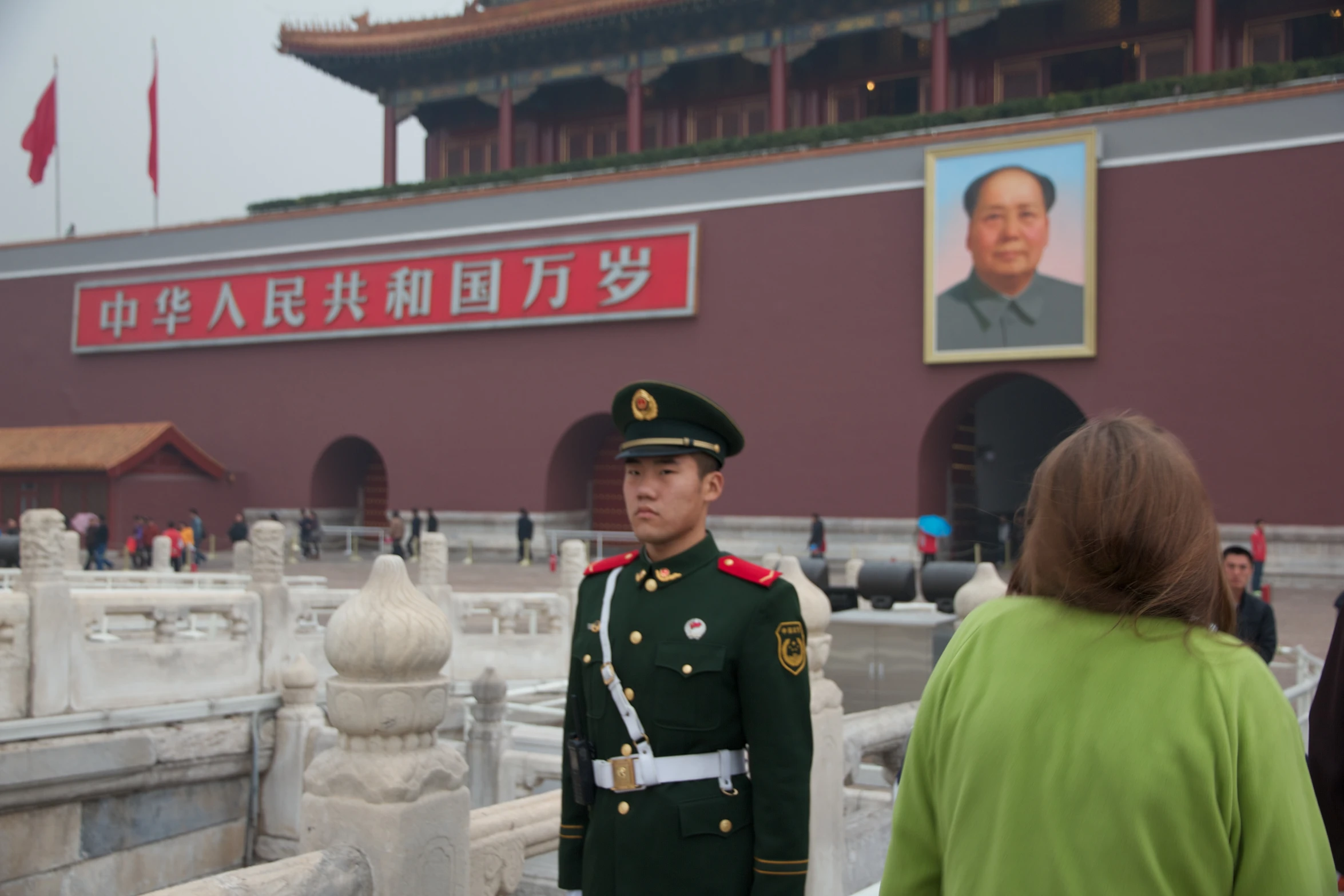 a man in uniform standing by a bridge near a building