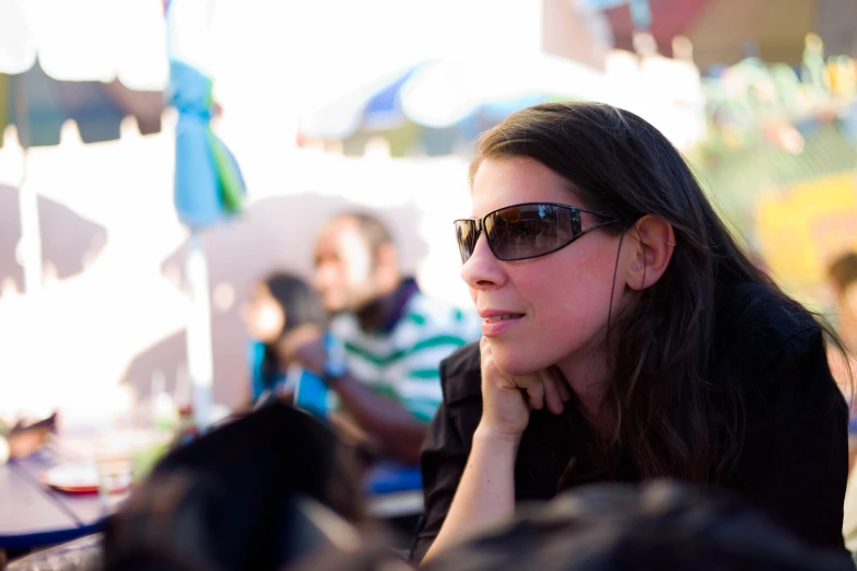 a woman wearing glasses at an event looks away