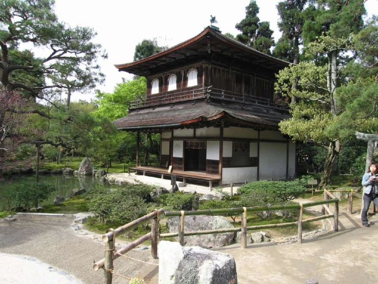 a person is standing in front of a building near some trees