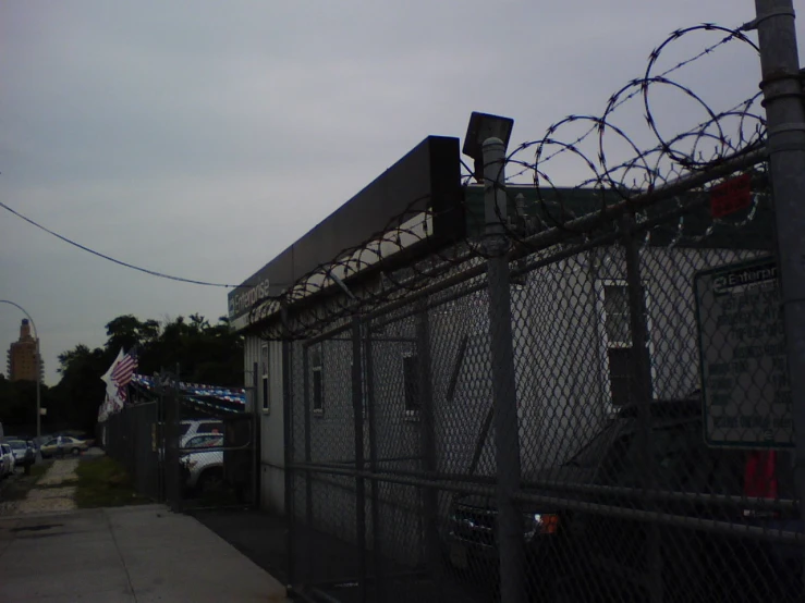 a building that is behind a fence with a lot of barbed wire