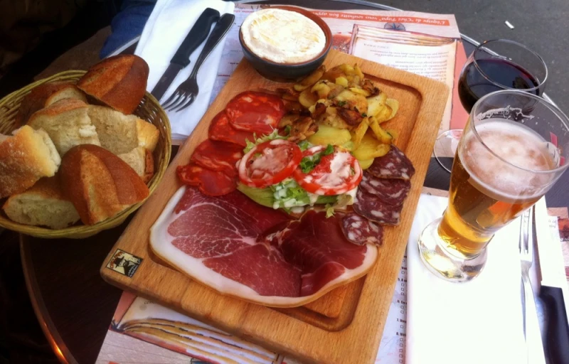 large  board holding meat, bread and vegetables