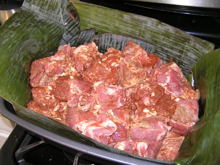 a large pan full of meat sits on the stove