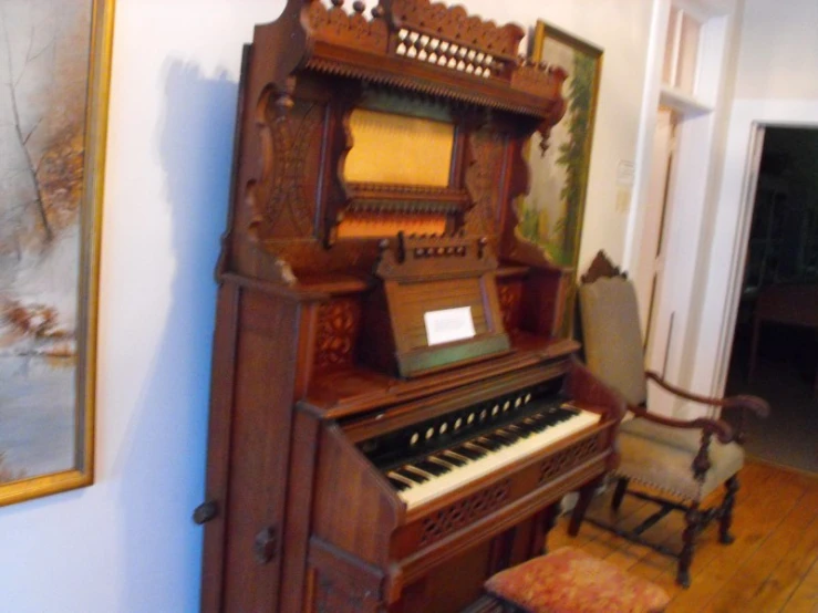 an old piano has ornate carved carvings and a fancy bench