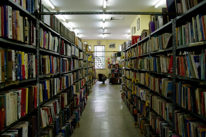 the long aisle of a liry with many books on shelves