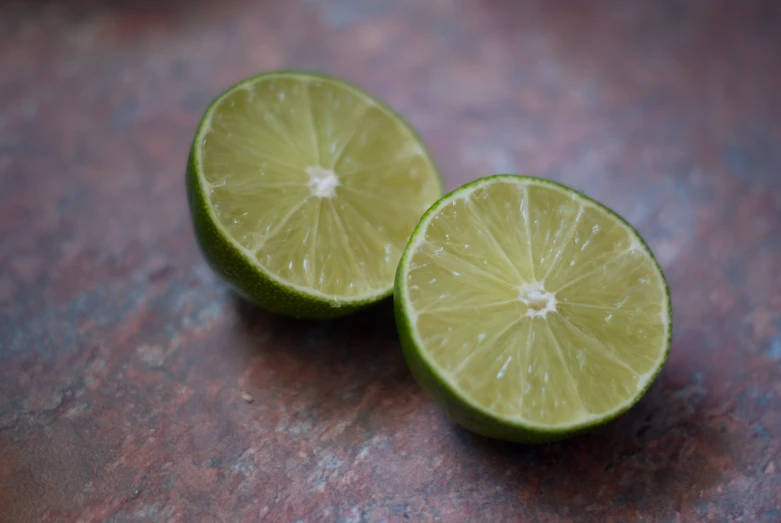 two lime halves cut open sitting on a table
