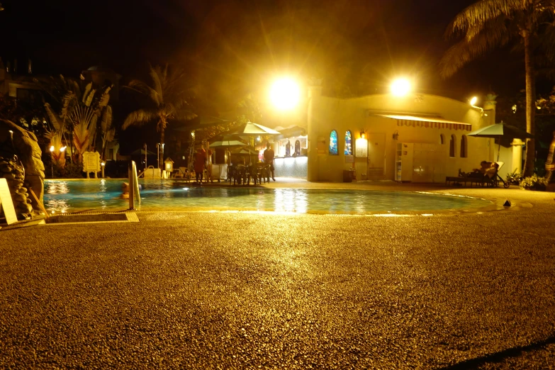 there is a building with some lights on near a swimming pool