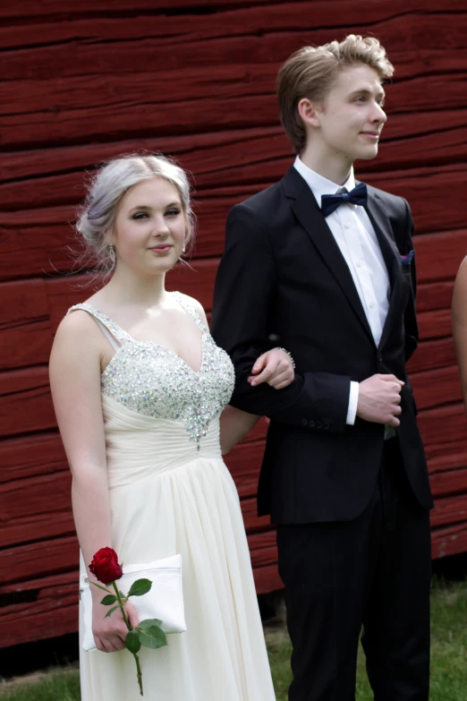 a man in a tuxedo standing next to a woman in a gown