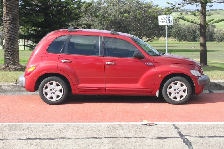 a small red suv parked on the side of the road