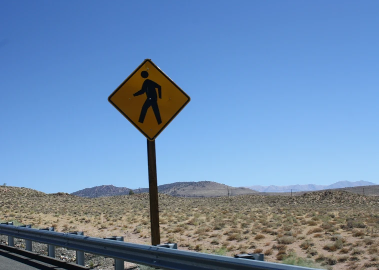 a yellow traffic sign sitting on the side of a highway