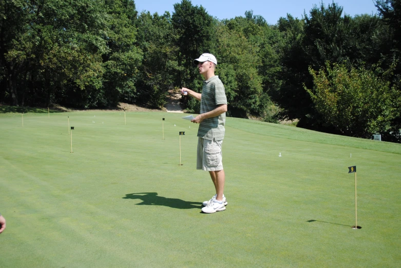 a boy is standing in the middle of a golf course