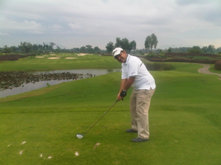 the man plays a golf ball on a green course