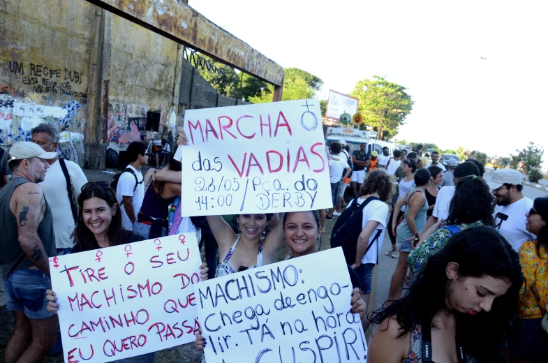 a crowd of people stand with signs